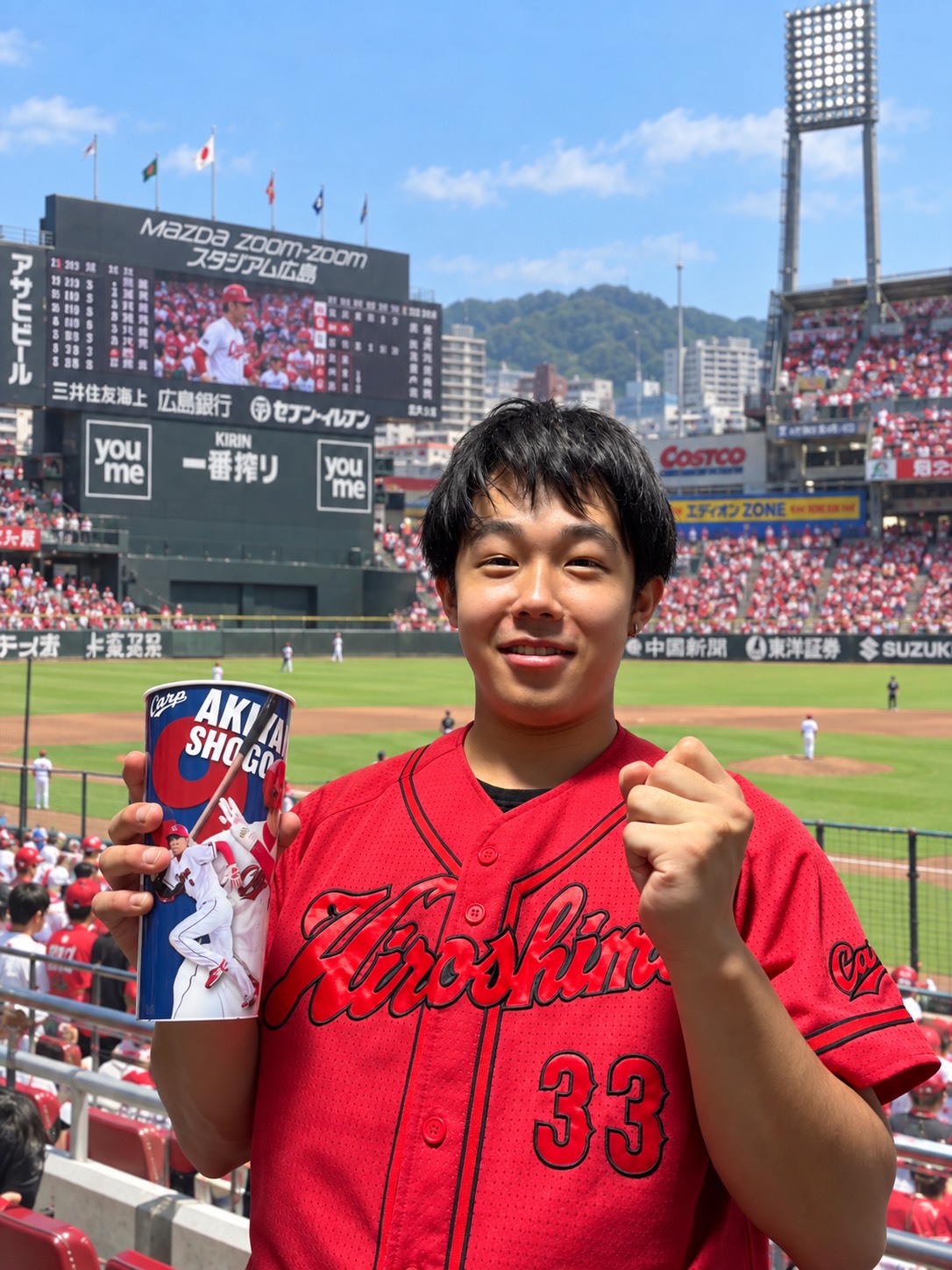 経営者100人に会う企画のインタビュアー藤瀬亮介が、カープのユニフォームで野球観戦を楽しむ姿